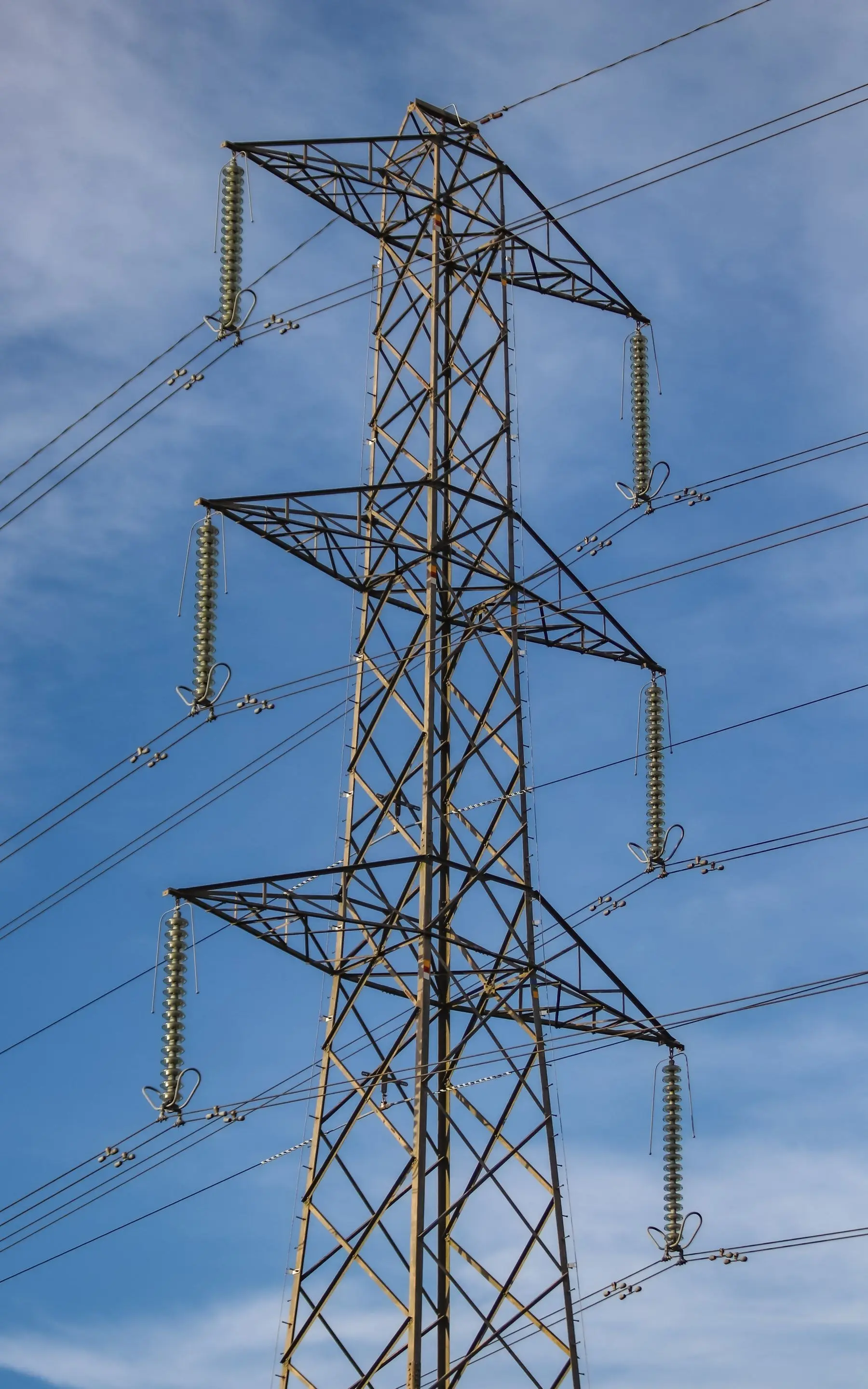 Høyspentmast med kraftledninger mot himmelen